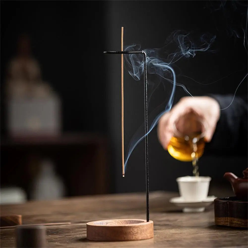 Incense stick with smoke on a wooden stand, blurred background