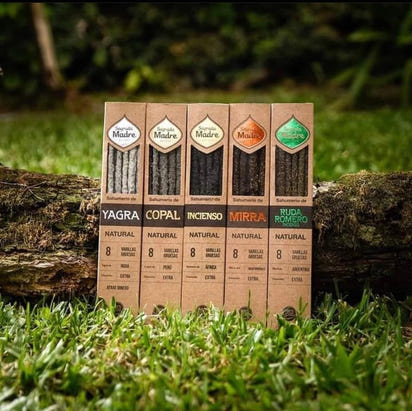 Five cardboard boxes of different incense brands on a grassy background